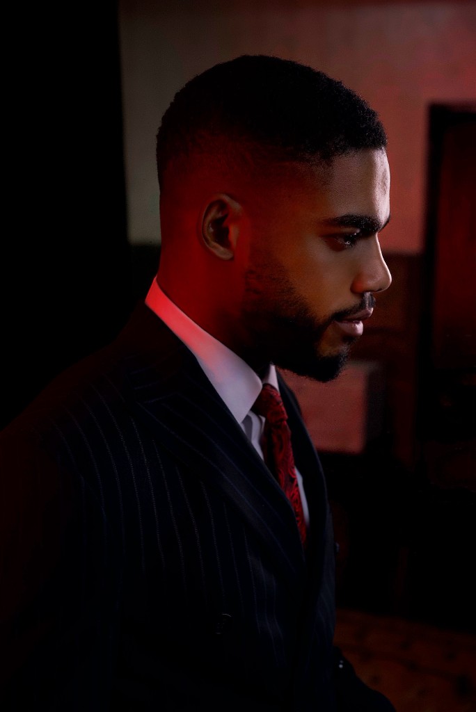 Profile of Osborn Nweze Umahi in a navy pinstripe suit, lit in red.
