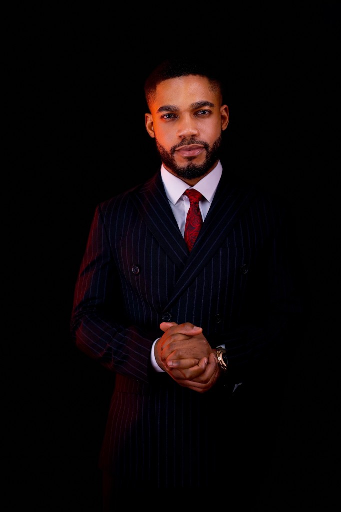Osborn Nweze Umahi standing in a navy pinstripe suit, hands clasped.