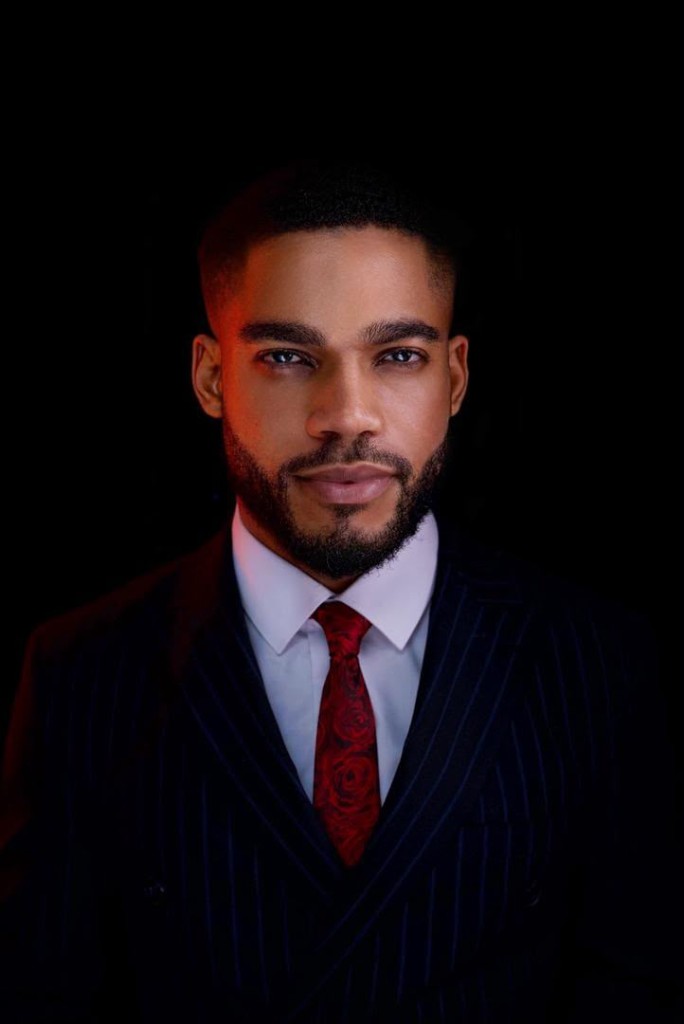 Portrait of Osborn Nweze Umahi in a dark pinstripe suit and red tie.